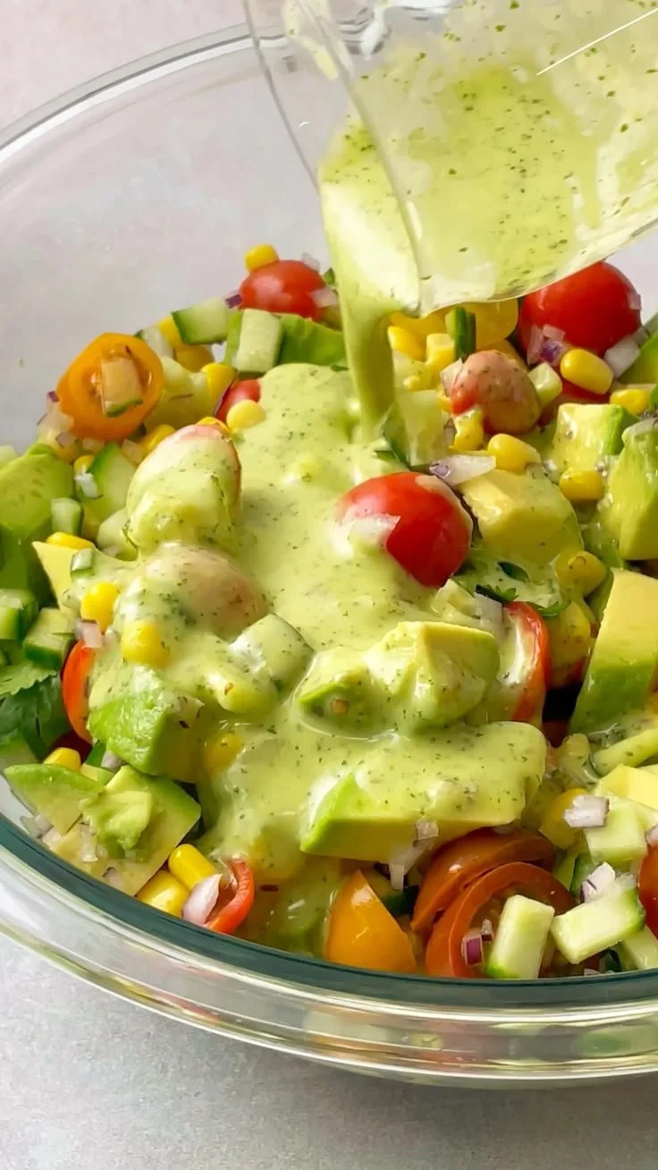 Fresh avocado salad with lime cilantro dressing served in a bowl.
