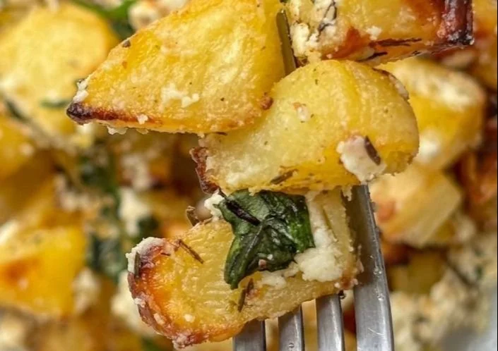 Delicious Baked Feta Potatoes served in a baking dish with herbs