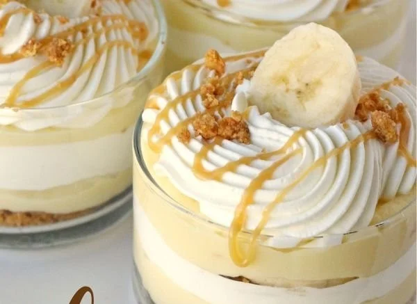 Delicious banana caramel cream dessert topped with whipped cream and banana slices