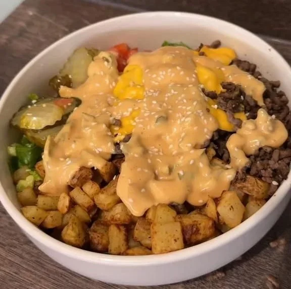 Delicious burger in a bowl with fresh ingredients and toppings