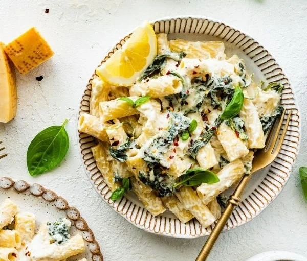 Plate of creamy lemon ricotta pasta with herbs and lemon zest