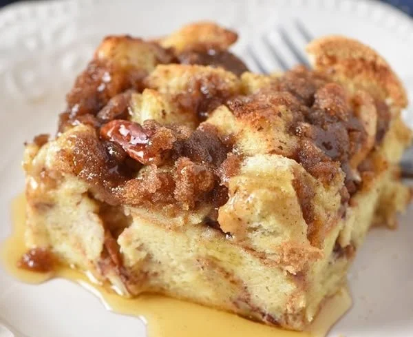 Delicious French toast casserole topped with syrup and berries