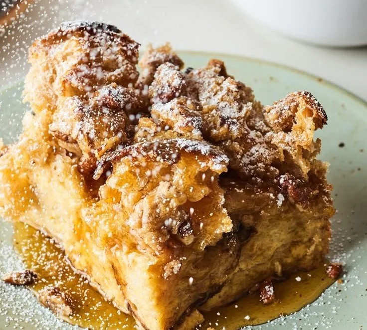 Delicious French Toast Casserole served with syrup and powdered sugar