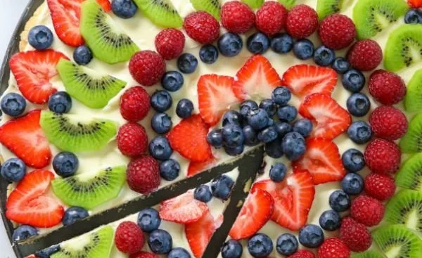 A colorful fruit pizza topped with assorted fresh fruits on a sweet crust.