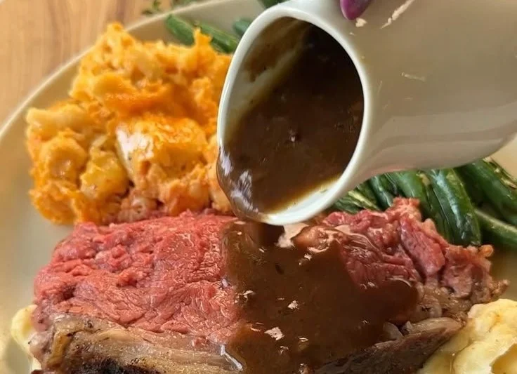 Garlic Butter Prime Rib 2 Delicious garlic butter prime rib served on a platter with herbs