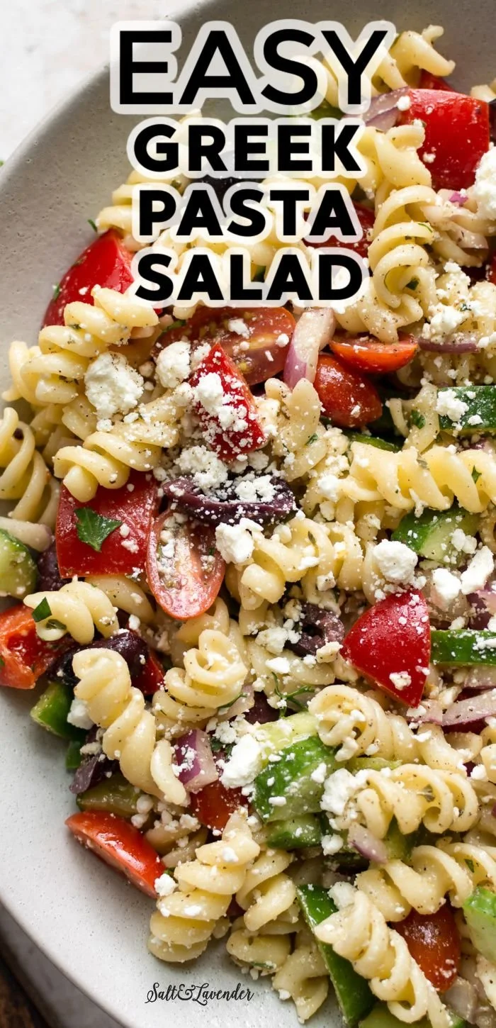 Bowl of Greek Pasta Salad with feta, olives, cucumbers, and cherry tomatoes.