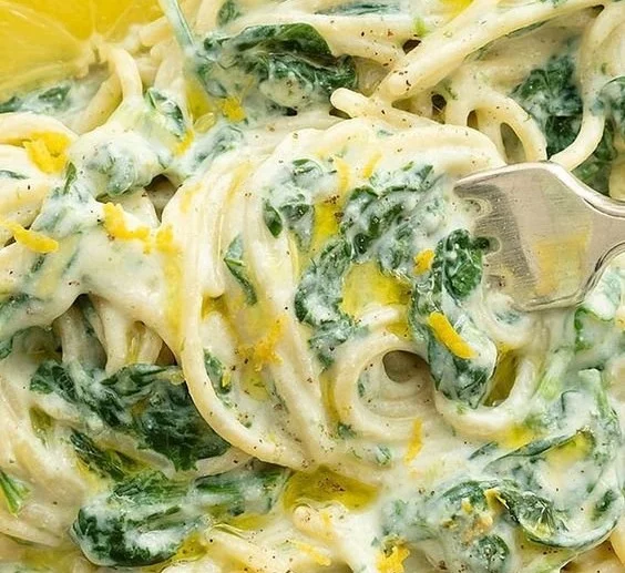 Delicious lemon ricotta pasta dish with fresh spinach garnished with herbs