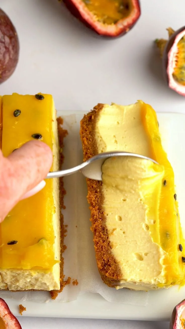 No-bake passion fruit cheesecake topped with fresh passion fruit and mint leaves.