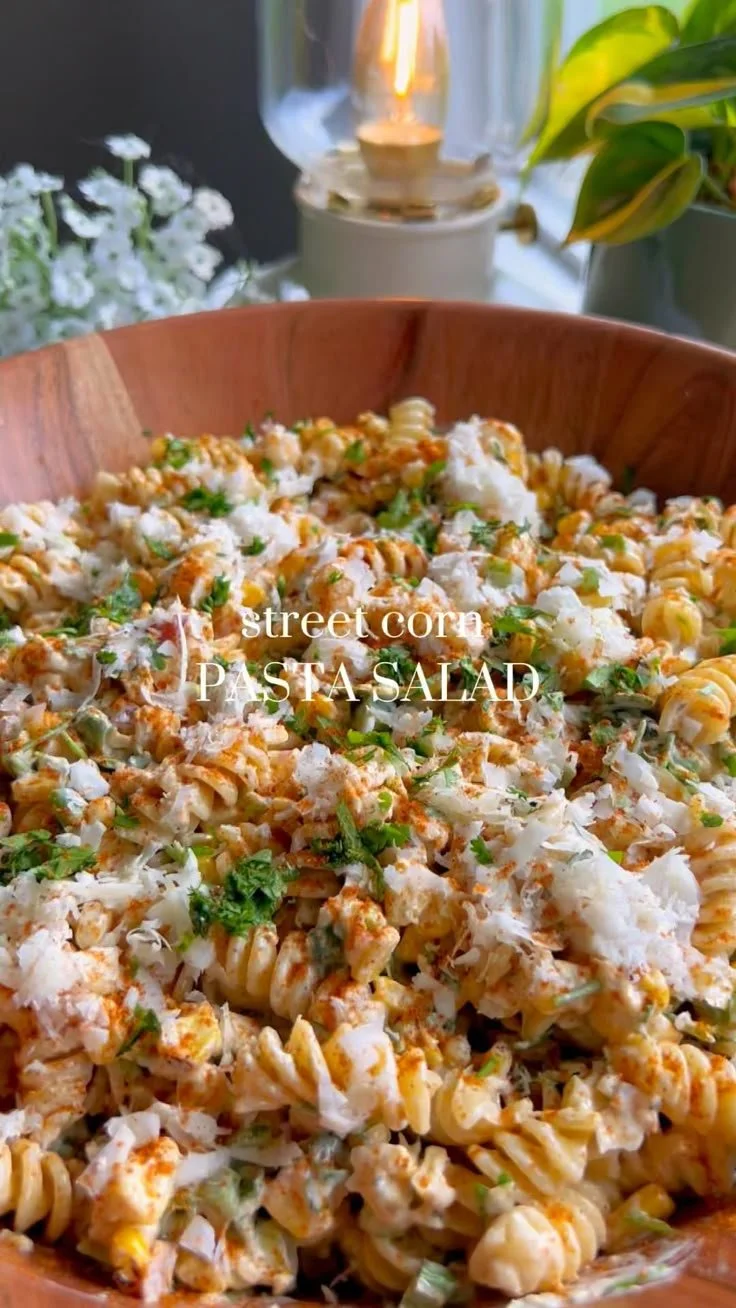 Delicious street corn pasta salad in a bowl topped with fresh herbs.