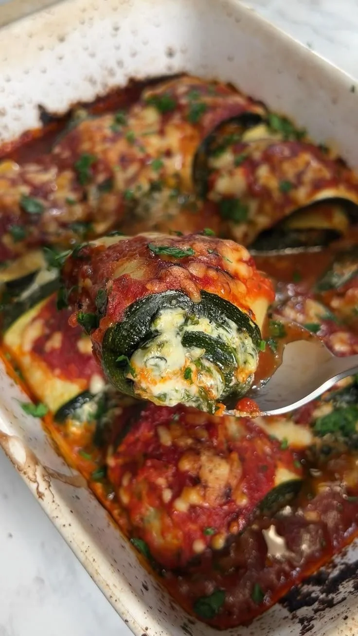 Delicious Zucchini Rollatini filled with cheese and herbs on a white plate